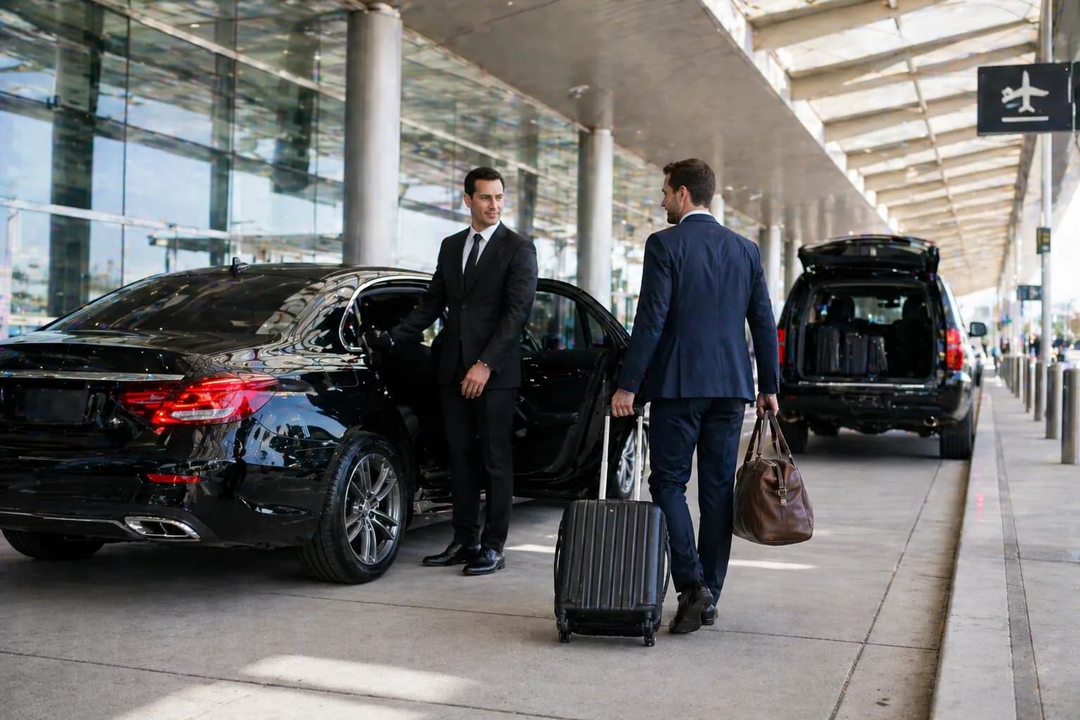 Chauffeur loading luggage into a luxury car at the airport